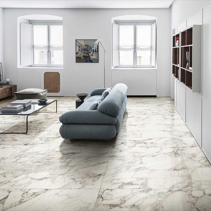 Living room featuring Maine Calacatta Matt Marble 30 × 60cm porcelain floor tiles, showcasing a soft white base with flowing grey veining, paired with minimalist furnishings, light walls, and natural light to create a calm, open, contemporary space.