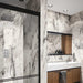 Bathroom interior featuring Maine Capraia Matt Marble 60 × 120cm porcelain wall tiles, showcasing a crisp white base with bold, dramatic grey veining, paired with black-framed shower detailing and warm wood cabinetry for a striking, contemporary contrast.