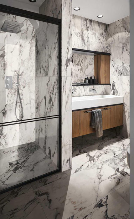 Bathroom interior featuring Maine Capraia Matt Marble 60 × 120cm porcelain wall tiles, showcasing a crisp white base with bold, dramatic grey veining, paired with black-framed shower detailing and warm wood cabinetry for a striking, contemporary contrast.