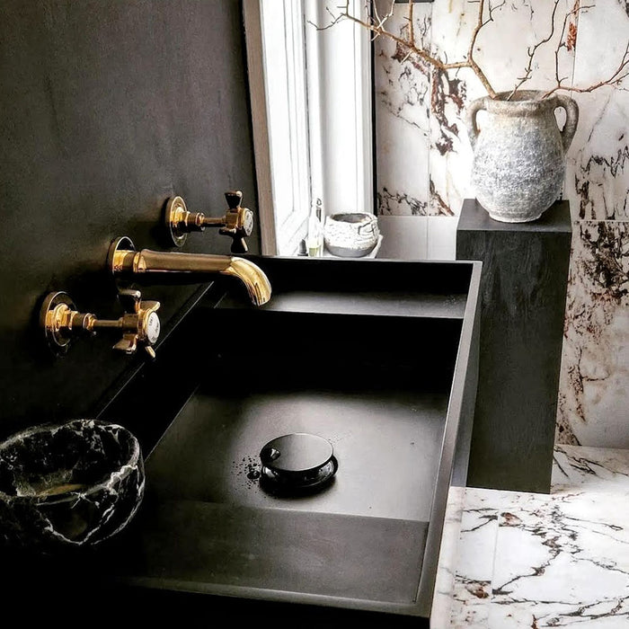 Bathroom interior featuring Maine Capraia Matt Marble 60 × 60cm porcelain wall and floor tiles, styled with bold dark veining against a soft white base, paired with black fixtures and warm brass accents for a striking, contemporary contrast.