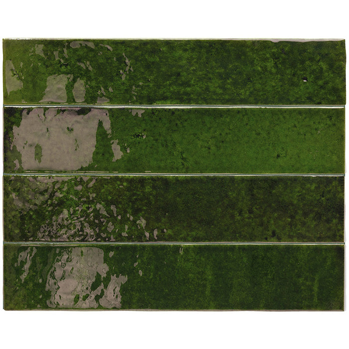 Flat lay of Malaga Tourmaline Green Brick 6.5 × 32.8cm gloss ceramic wall tiles, arranged to showcase rich green tonal variation, a reflective glossy finish, and softly irregular handcrafted detailing for a bold, characterful look.