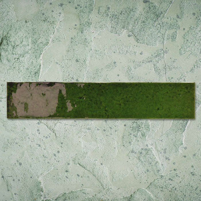 Single Malaga Tourmaline Green Brick 6.5 × 32.8cm gloss ceramic wall tile, showcasing rich green tonal variation, a reflective handcrafted-style finish, and softly weathered detailing for added depth and character.