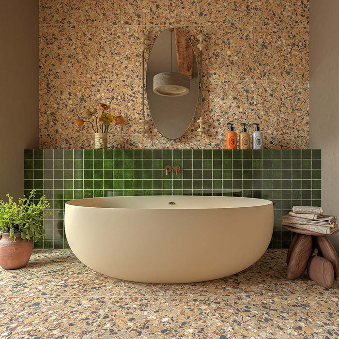Bathroom featuring Malaga Tourmaline Green Square Gloss Wall Tiles 10cm x 10cm, paired with terrazzo effect wall and floor tiles, a freestanding bath, brushed brass fittings and warm natural textures for a contemporary spa-inspired design.