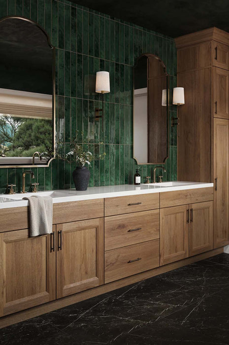 Bathroom vanity featuring Maldives Pine Green 5 × 40cm gloss ceramic wall tiles, laid vertically with rich green tonal variation, paired with wooden cabinetry, twin basins, brass fittings, and framed mirrors for a refined, design-led finish.