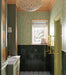 Bathroom interior featuring Maldives Pine Green 5 × 40cm gloss ceramic wall tiles, laid vertically across the lower walls with deep green tonal variation, paired with brass fixtures, patterned floor tiles, and soft green joinery for a cohesive, classic finish.