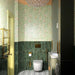 Bathroom interior featuring Maldives Pine Green 5 × 40cm gloss ceramic wall tiles, laid vertically across the lower walls with rich green tonal variation, paired with brass fittings, patterned floor tiles, and soft green panelling for a refined, layered look.