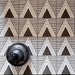 Alhambra Pyramid 20x20cm Moroccan tiles displayed in a bold black and white triangular pattern, styled with a decorative black lantern accent for a modern geometric marketing setup.