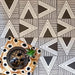 Alhambra Pyramid 20x20cm Moroccan tiles arranged in a striking black and white triangular pattern, styled with a patterned cushion, a decorative tray, and a small succulent plant for a modern Moroccan-inspired display.
