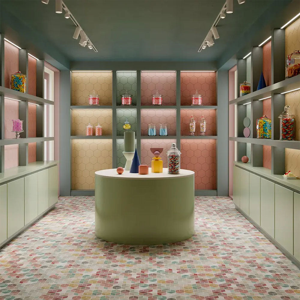 Interior setting featuring Candy Colours multicoloured hexagon patchwork Moroccan-style porcelain floor tiles in a 17x15cm format, showcasing a playful mix of pastel tones in a modern retail-style space.
