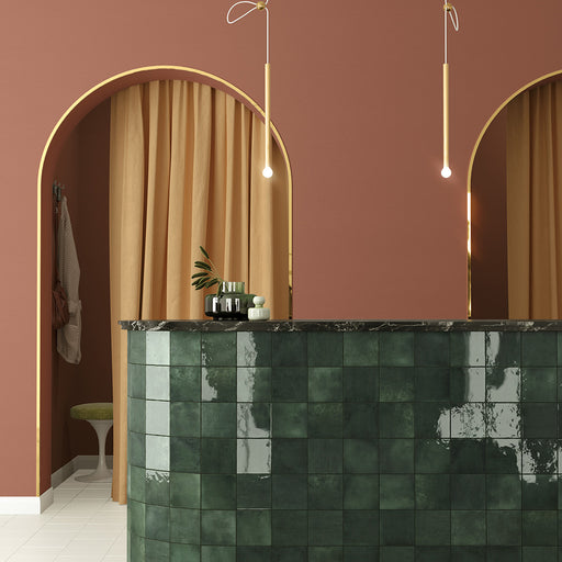 Zellij Gloss Green square Moroccan style tiles, 13.2cm x 13.2cm, deep green tones with natural tonal variation, high-gloss glazed finish, handmade look, square format used in a curved bar-style marketing setting.