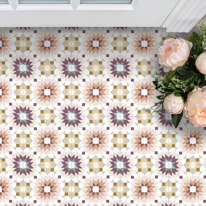 Cabana Manzanillo 20x20cm Moroccan-style porcelain tiles in a geometric star pattern featuring blush pink, mustard, terracotta, lilac, and turquoise tones with a matt finish, styled in a bright floral interior setting.