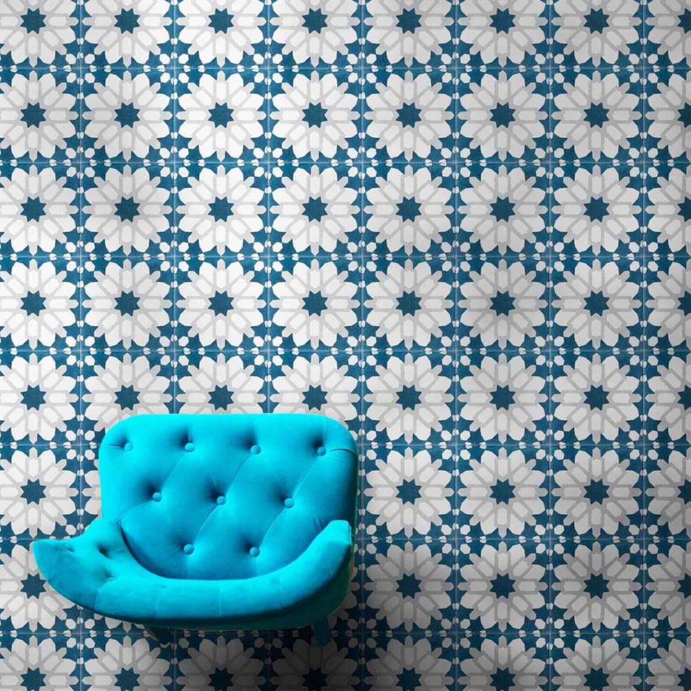 Marketing setting featuring Soukaina Blue D Moroccan-style 20cm x 20cm patterned porcelain wall tiles, showcasing a repeating geometric star design in deep blue, white and soft neutral tones with a matt finish, styled with a bold turquoise accent chair.