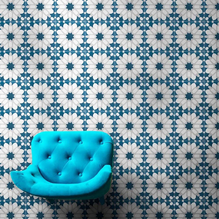 Marketing setting featuring Soukaina Blue D Moroccan-style 20cm x 20cm patterned porcelain wall tiles, showcasing a repeating geometric star design in deep blue, white and soft neutral tones with a matt finish, styled with a bold turquoise accent chair.