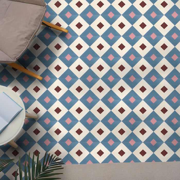 Cabana Guazzatto 20x20cm Moroccan-style porcelain tiles in a modern geometric diamond pattern featuring blue, cream, pink, and burgundy tones with a smooth matt finish, shown in a living space setting.
