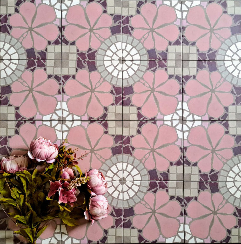 Bloom Rose Pink 20x20cm Moroccan-style ceramic tiles in a marketing flat-lay setting, featuring decorative floral patterns in soft pink, white, and taupe tones, styled with pink flowers for a coordinated look.