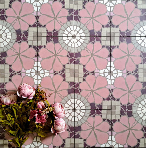 Bloom Rose Pink 20x20cm Moroccan-style ceramic tiles in a marketing flat-lay setting, featuring decorative floral patterns in soft pink, white, and taupe tones, styled with pink flowers for a coordinated look.