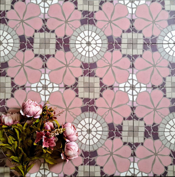 Bloom Rose Pink 20x20cm Moroccan-style ceramic tiles in a marketing flat-lay setting, featuring decorative floral patterns in soft pink, white, and taupe tones, styled with pink flowers for a coordinated look.