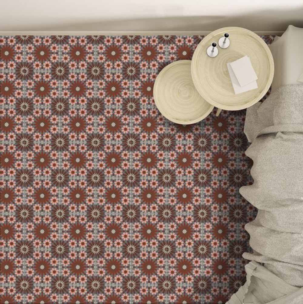 Interior setting featuring Fizaan Rosso 20x20cm Moroccan-style porcelain floor tiles, showcasing a repeating geometric pattern in warm red, soft blue and neutral tones, styled with light wood side tables.