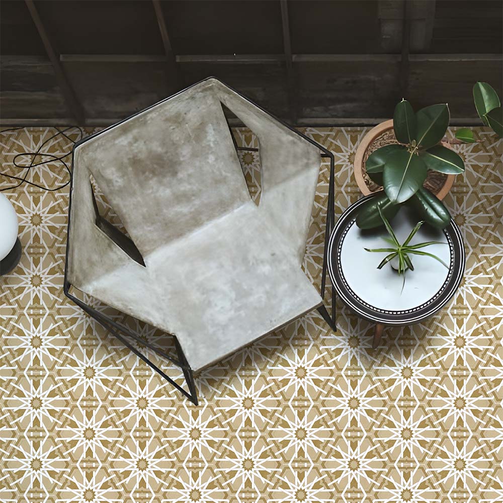 Maroush Mareshan Vintage Gold 18.7x21.6cm Moroccan hexagonal tiles with intricate white star patterns, styled in a modern interior with a concrete chair, potted plants, and warm golden tones for an artisan-inspired look.