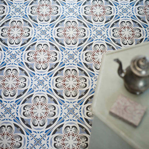 Empire Blue 15x15cm Victorian-style floor tiles in a marketing setting, featuring intricate floral and geometric motifs in blue, grey, white, and terracotta tones for a classic heritage look.