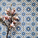 Flatlay featuring Clarence House Azul Blue 20x20cm Victorian Moroccan-style porcelain tiles, styled with pink magnolia flowers to highlight the intricate blue and white geometric pattern.