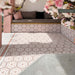 Outdoor seating area featuring Maroush Dusty Pink 18.7cm x 21.6cm Moroccan style hexagon tiles across the floor and built-in seating, showcasing an intricate pink and white geometric pattern with coordinating border tiles.