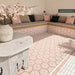 Outdoor seating area featuring Maroush Dusty Pink 18.7cm x 21.6cm Moroccan style hexagon tiles across the floor and built-in seating, showcasing an intricate pink and white geometric pattern with coordinating border tiles.