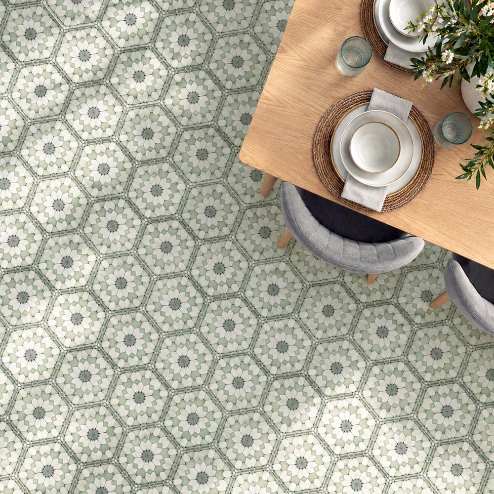 Dining room featuring Maroush Green 18.7x21.6cm Moroccan-style hexagon floor tiles, with intricate sage green, white and grey floral patterns, paired with a light oak dining table, upholstered chairs and natural woven accessories.