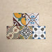 Fihrdos Mini Patchwork Moroccan-style 15x15cm patterned porcelain tiles arranged in a grouped layout, showcasing a mix of colourful geometric and traditional decorative designs.