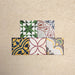 Fihrdos Mini Patchwork Moroccan-style 15x15cm patterned porcelain tiles arranged in a grouped layout, showcasing a mix of colourful geometric and traditional decorative designs.
