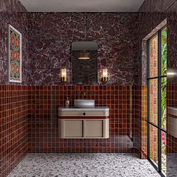 Luxury bathroom featuring Mizu Golden Caramel Square gloss porcelain tiles in 10cm x 10cm. Rich golden caramel square wall tiles with a glossy finish wrap the lower walls, creating warmth and contrast against dramatic burgundy marble effect porcelain tiles and terrazzo effect floor tiles.