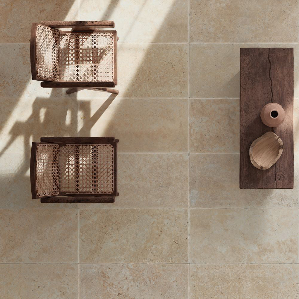Monastry Flagstone XL Beige Travertine 50 × 100cm porcelain slabs, styled with warm wood furniture and woven textures to highlight soft tonal variation, a gently aged finish, and a natural travertine effect.