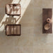 Monastry Flagstone XL Beige Travertine 50 × 100cm porcelain slabs, styled with warm wood furniture and woven textures to highlight soft tonal variation, a gently aged finish, and a natural travertine effect.