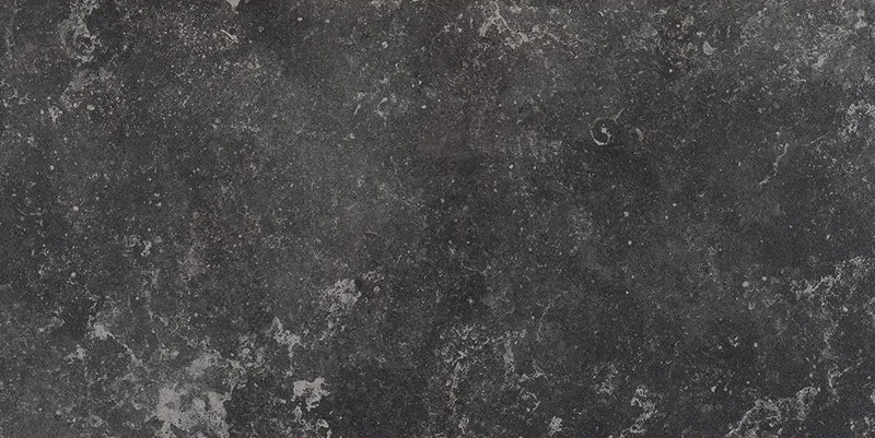 Modern bathroom featuring Obsidian Stone Nite 30x60cm stone-effect porcelain wall and floor tiles in deep charcoal tones, styled with a freestanding bath, black accents, textured mosaics and minimalist contemporary décor.