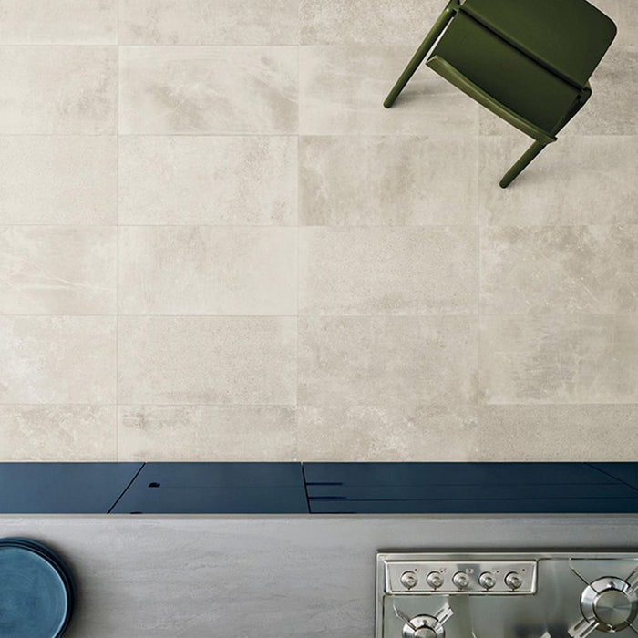 Kitchen featuring Obsidian Stone Sand 30x60cm stone-effect porcelain wall tiles in soft beige tones, styled with dark worktops, stainless steel appliances and minimalist contemporary interiors with warm natural textures.