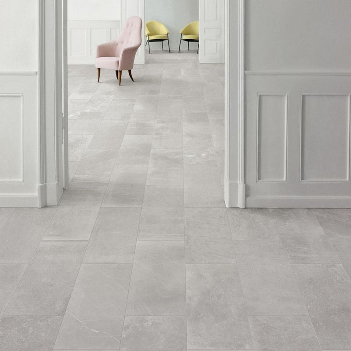 Interior hallway featuring Obsidian Stone Silver 30x60cm stone-effect porcelain floor tiles in soft silver-grey tones, styled with classic wall panelling, pastel accent chairs and elegant contemporary interiors with natural light.