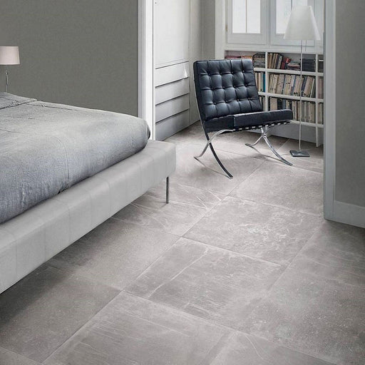 Bedroom featuring Obsidian Stone Titanium 30x60cm stone-effect porcelain floor tiles in mid-grey tones, styled with soft neutral interiors, modern furnishings, chrome accents and minimalist contemporary décor.