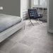 Bedroom featuring Obsidian Stone Titanium 30x60cm stone-effect porcelain floor tiles in mid-grey tones, styled with soft neutral interiors, modern furnishings, chrome accents and minimalist contemporary décor.