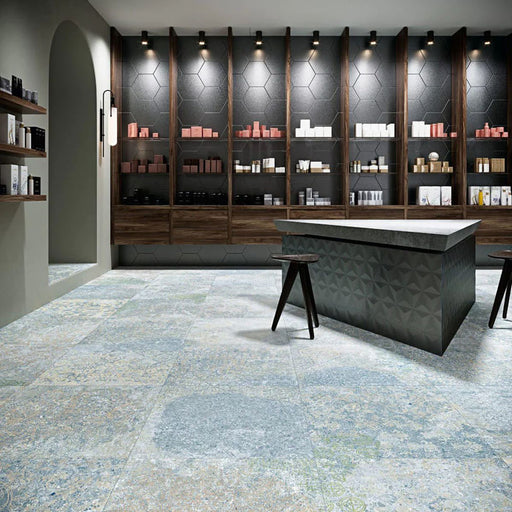 Interior featuring Boheme Ocean Blue 60 × 60cm patterned floor tiles, blending soft blue and muted tones with a worn, decorative effect. Ideal for adding character to contemporary spaces such as retail interiors, kitchens, or open-plan living areas.