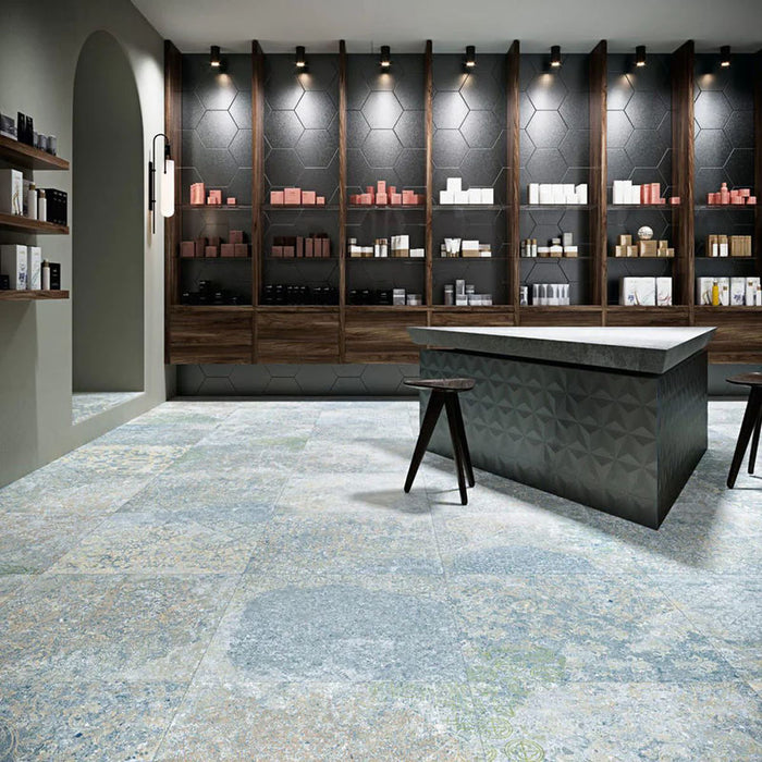 Interior featuring Boheme Ocean Blue 60 × 60cm patterned floor tiles, blending soft blue and muted tones with a worn, decorative effect. Ideal for adding character to contemporary spaces such as retail interiors, kitchens, or open-plan living areas.