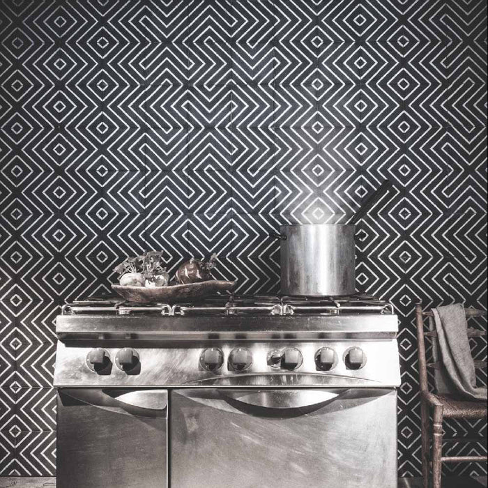 Alhambra Zig Zag Black 20x20cm Moroccan tiles used as a kitchen splashback behind a stainless steel oven, featuring bold black and white chevron patterns for a striking geometric statement wall.