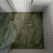 Bathroom featuring Paradis Marble Verde Green stone marble effect porcelain wall tiles in a 30cm x 60cm format, showcasing flowing green, sage and soft white veining inspired by natural marble, paired with a freestanding white bath, brushed brass brassware, neutral accessories and soft natural lighting for a luxurious spa-inspired interior.