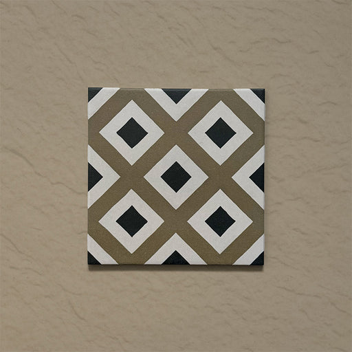 Single tile from the Carnaby Park Road Victorian-style collection, 20x20cm porcelain wall and floor tile, featuring a repeating diamond geometric pattern in olive, white, and black tones.