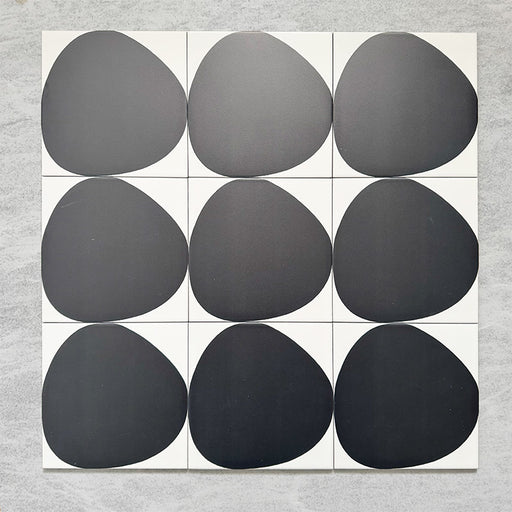 Pebble Beach Reversed Black 20x20cm patterned tiles featuring a bold black organic circular design, ideal for creating striking monochrome floors and statement walls with a contemporary geometric aesthetic.