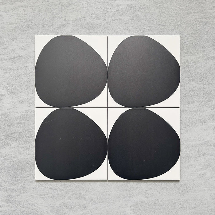 Pebble Beach Reversed Black 20x20cm patterned tiles featuring a bold black organic circular design, ideal for creating striking monochrome floors and statement walls with a contemporary geometric aesthetic.