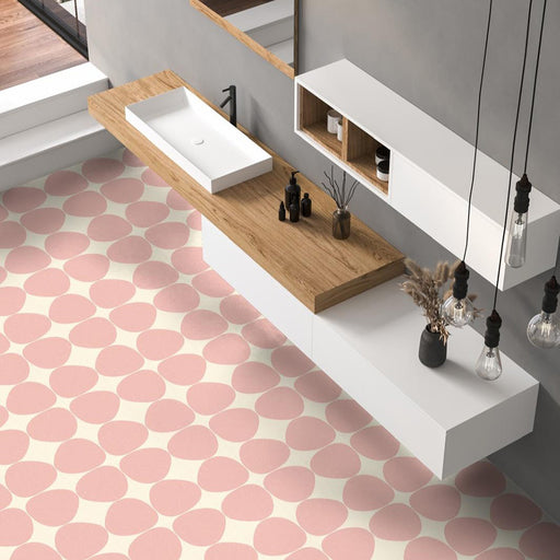 Contemporary bathroom featuring Pebble Beach Reversed Pink 20x20cm patterned floor tiles, styled with soft blush tones, floating oak cabinetry, and minimalist white fittings for a playful modern interior.