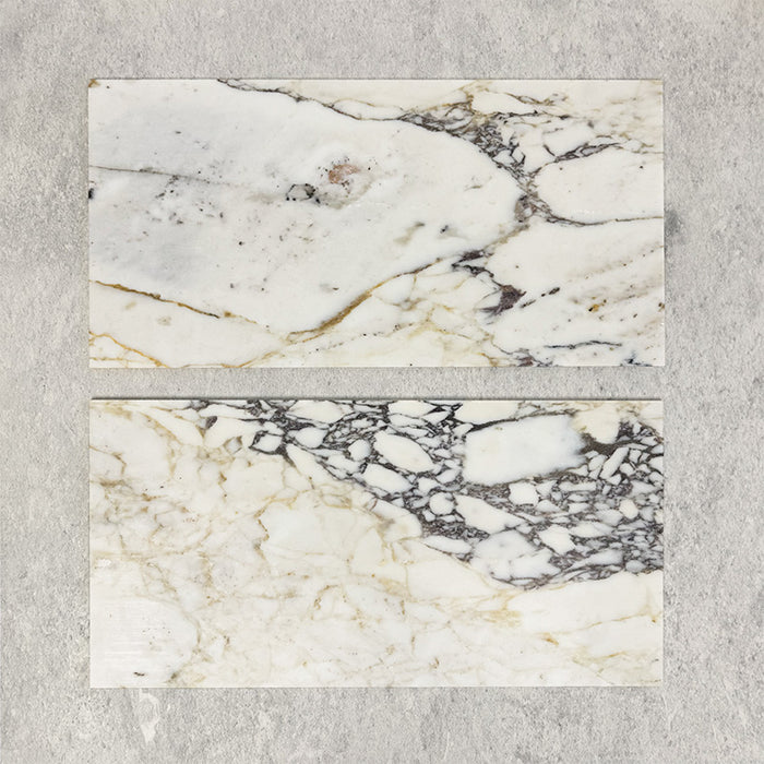 Close-up of Fitzrovia Picasso natural marble tiles in a honed finish, 30.5x61cm format, showcasing a soft white base with warm beige undertones and distinctive, organic veining, creating a refined and elegant look for wall and floor applications.