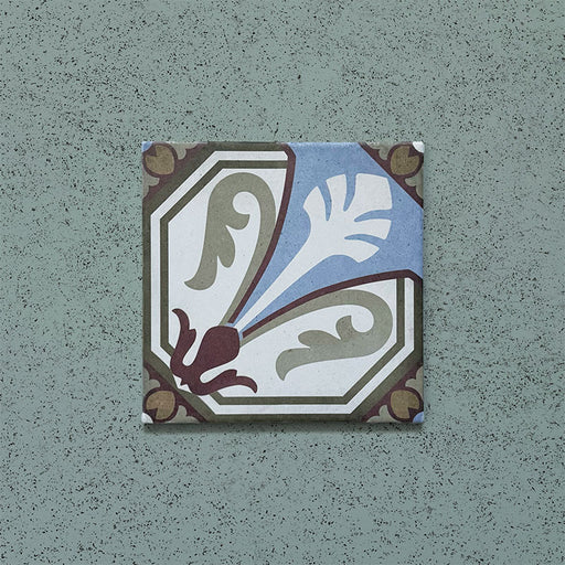 Single tile from the Carnaby Place Victorian-style collection, 20x20cm porcelain wall and floor tile, featuring an ornate floral motif in olive, blue, cream, and deep red tones on an aged background.