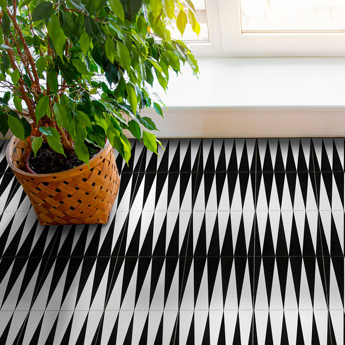 Alhambra Tavla 20x20cm Moroccan tiles used as flooring, featuring a bold black and white triangular pattern with a woven plant pot beside a bright window for a modern, minimalist look.