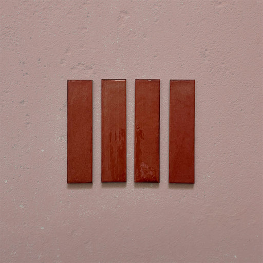 Product image of Play Coral Rectified Brick 5x20cm wall and floor tiles, featuring a glossy coral finish with rich tonal variation and clean rectified edges, displayed to highlight the tile's contemporary handcrafted appearance.